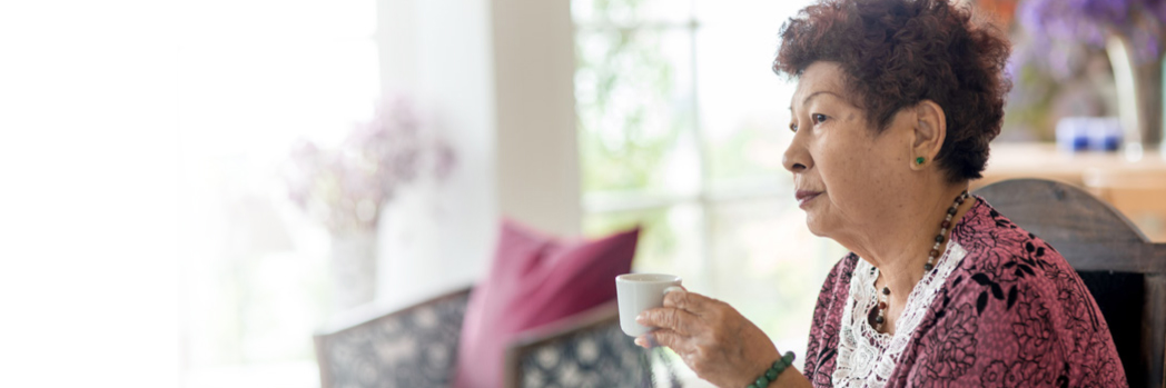 אישה מבוגרת אוחזת ספל